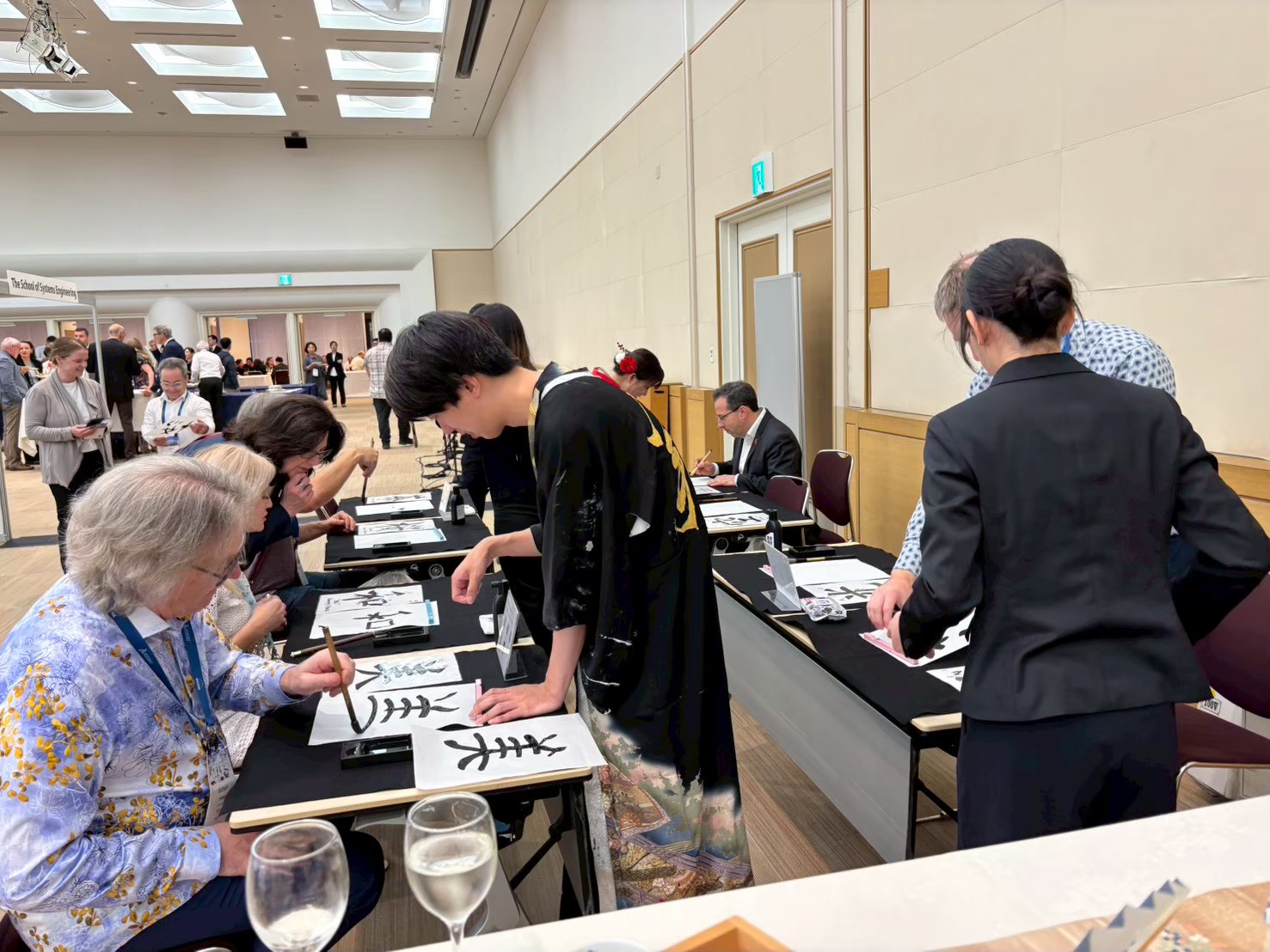 International guests experiencing Japanese calligraphy at a Yokohama DMC event