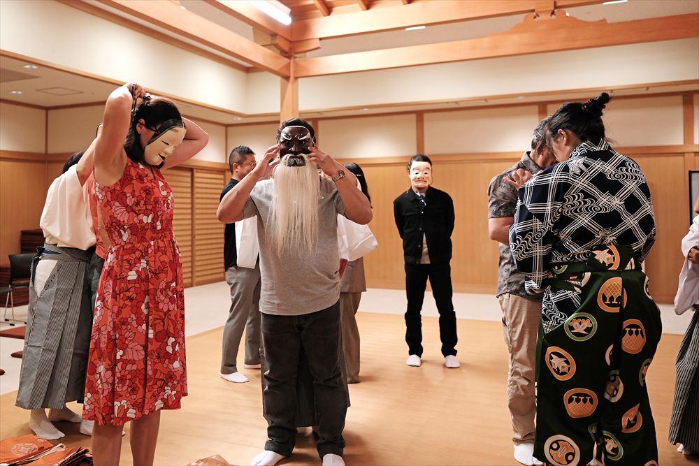 International participant experiencing a traditional Kagura mask